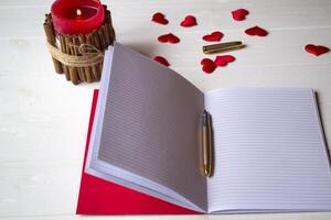Red candles, love hearts and notebook on the table. Beautiful bckground with copy space. photo