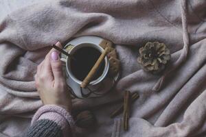 A cup of coffee, cinnamon stick, walnuts and pine cone on the table, top view. Beautiful flat lay with coffee. photo