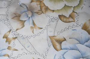 A floral patterned wallpaper with a lace border photo