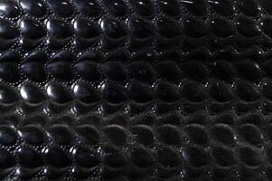 A close up of a black leather item with a pattern of small black dots photo