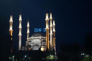 A large white mosque with a blue sign photo