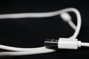 un blanco USB cable con un negro antecedentes foto