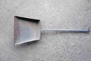 A metal spatula is laying on a grey surface photo