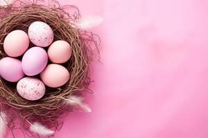 Easter holiday celebration banner greeting card with pastel painted eggs in bird nest on bright pink backround tabel texture.. Top view, flat lay with copy space photo