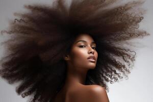 closeup of beautiful black african american young female model woman shaking her beautiful afro hair in motion. ad for shampoo conditioner hair products. isolated on white background photo