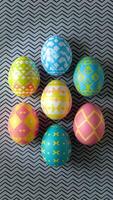 Seven Easter eggs on grey and black patterned background Vertical Mobile Wallpaper photo