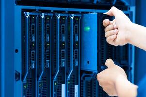 IT engineer repairing a server in a datacenter photo