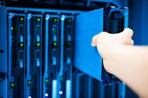 IT engineer repairing a server in a datacenter photo