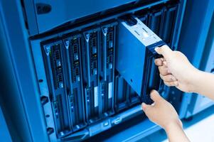 IT engineer repairing a server in a datacenter photo