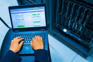 IT engineer repairing a server in a datacenter photo