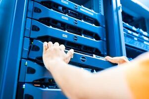 IT engineer repairing a server in a datacenter photo