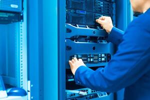 IT engineer repairing a server in a datacenter photo