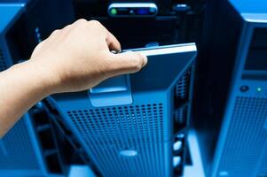 IT engineer repairing a server in a datacenter photo