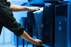 IT engineer repairing a server in a datacenter photo