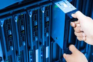 IT engineer repairing a server in a datacenter photo