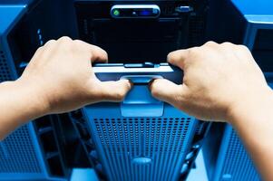 IT engineer repairing a server in a datacenter photo