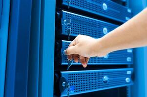 IT engineer repairing a server in a datacenter photo