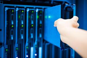 IT engineer repairing a server in a datacenter photo