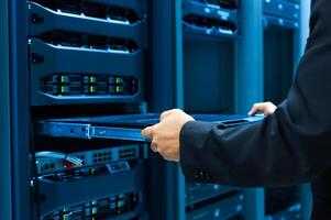 IT engineer repairing a server in a datacenter photo