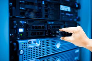 IT engineer repairing a server in a datacenter photo