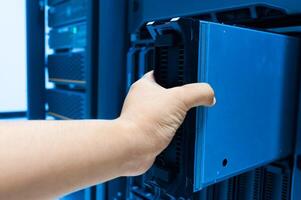 IT engineer repairing a server in a datacenter photo