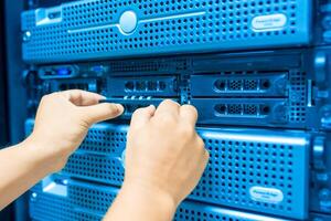 IT engineer repairing a server in a datacenter photo