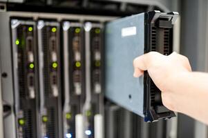 IT engineer repairing a server in a datacenter photo