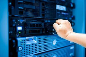 IT engineer repairing a server in a datacenter photo