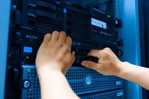 IT engineer repairing a server in a datacenter photo