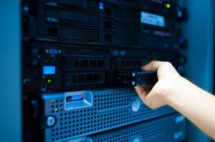 IT engineer repairing a server in a datacenter photo