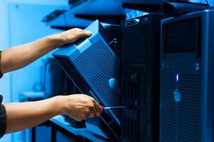 IT engineer repairing a server in a datacenter photo