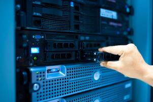 IT engineer repairing a server in a datacenter photo