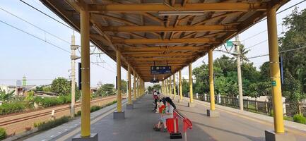 Activity people at railway train station Bekasi. Local train Indonesia. Railway road. West Java, Indonesia - April 8 2024 photo