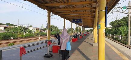 actividad personas a ferrocarril tren estación bekasi. local tren Indonesia. ferrocarril la carretera. Oeste Java, Indonesia - abril 8 2024 foto