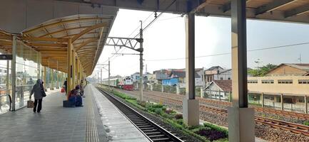 Activity people at railway train station Bekasi. Local train Indonesia. Railway road. West Java, Indonesia - April 8 2024 photo