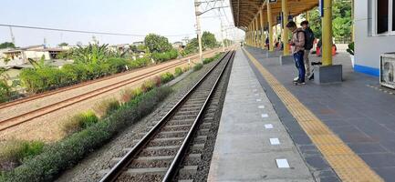 Activity people at railway train station Bekasi. Local train Indonesia. Railway road. West Java, Indonesia - April 8 2024 photo