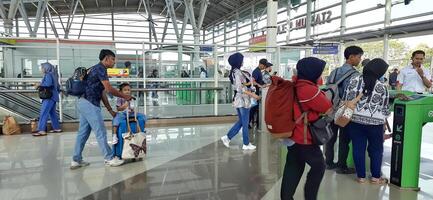 The atmosphere travelers or mudik lebaran or pulang kampung or idul fitri moments in train station Bekasi. West Java, Indonesia - April 8 2024 photo