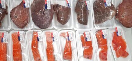Fresco crudo carne pollo y carne de vaca en monitor en supermercado frío estantes. bekasi, Oeste Java, Indonesia - marzo 8 2024 foto