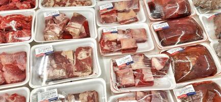 Fresh raw meat chicken and beef on display in supermarket cold shelves. Bekasi, West Java, Indonesia - March 8 2024 photo