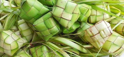 ketupat o arroz bola de masa hervida. un tradicional arroz caja hecho desde joven Coco hojas para Cocinando arroz vendido en tradicional mercado preparación para el eid al-fitr fiesta para musulmán foto