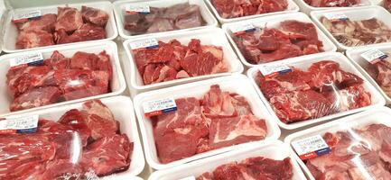 Fresh raw meat chicken and beef on display in supermarket cold shelves. Bekasi, West Java, Indonesia - March 8 2024 photo