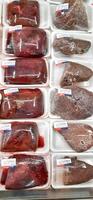 Fresh raw meat chicken and beef on display in supermarket cold shelves. Bekasi, West Java, Indonesia - March 8 2024 photo