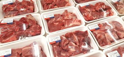 Fresh raw meat chicken and beef on display in supermarket cold shelves. Bekasi, West Java, Indonesia - March 8 2024 photo