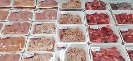 Fresh raw meat chicken and beef on display in supermarket cold shelves. Bekasi, West Java, Indonesia - March 8 2024 photo