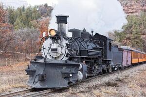 Clásico vapor tren ondulante fumar como eso se mueve mediante el montañas. foto