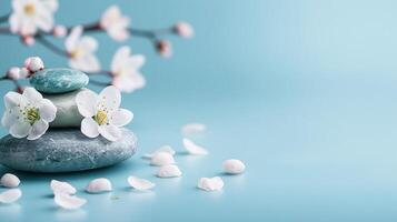 Relaxation banner with serene balance of smooth stones and white cherry blossoms on a tranquil blue backdrop for wellness, spa, and mindfulness themes. photo