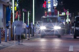 un noche paisaje urbano de el multitud a el neón pueblo en Shinjuku tokio largo Disparo foto