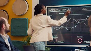 Startup team reviewing annual reports infographics on interactive board, studying market entry approaches and demands to facilitate global growth. Business employees accomplish goals. Camera A. video