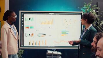 Marketing und pr Mannschaft Treffen zu analysieren Infografiken im Konferenz Zimmer, Teilen Ideen zum korporativ branding und Ruf Strategien. bauen und pflegen ein positiv Öffentlichkeit Bild. Kamera b. video