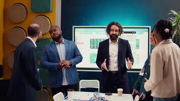 Team of startup employees gathering for a briefing session in boardroom, developing strategies to improve corporate culture and personnel engagement in multiple projects. Camera B. video